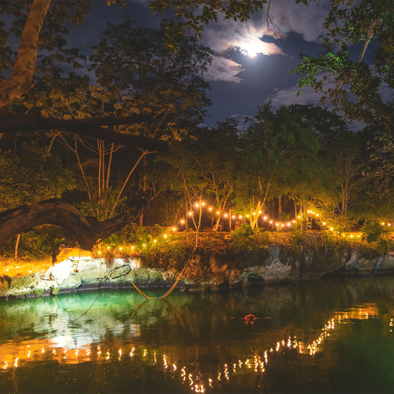 Cenote at night illuminated by lights