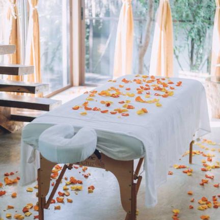 White massage bed with orange petals