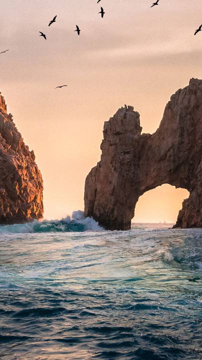 Large rock formation in form of an arch over the ocean