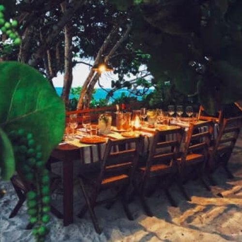 Decorated table in the middle of the sand and tropical jungle