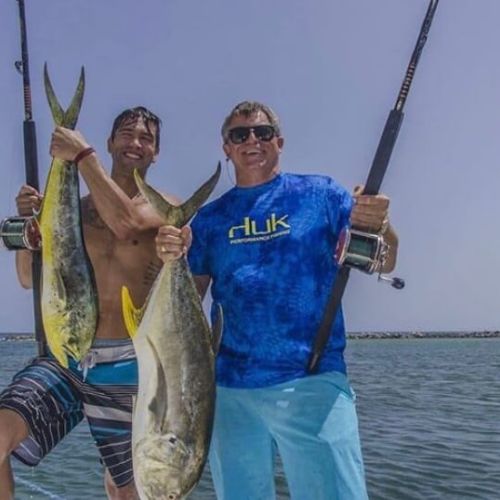 2 guys holding large fishes