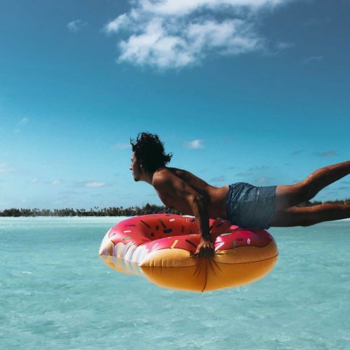 Guy launching to the ocean on a doughnut pool float