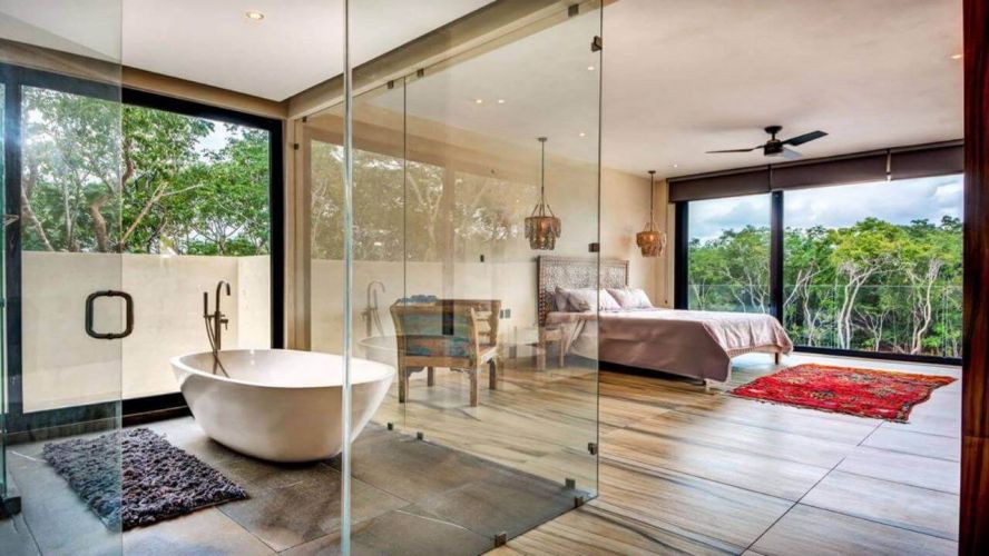 Bathtub surrounded by glass doors inside bedroom